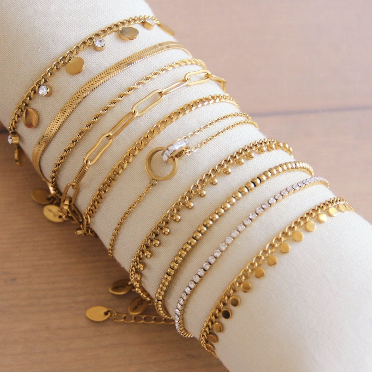 SA832: Stalen schakelarmband met muntjes - goud
