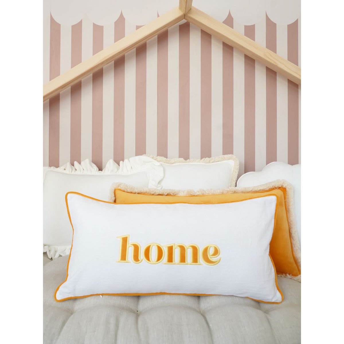 Decoratieve kussensloop met geel geborduurd opschrift "Home"